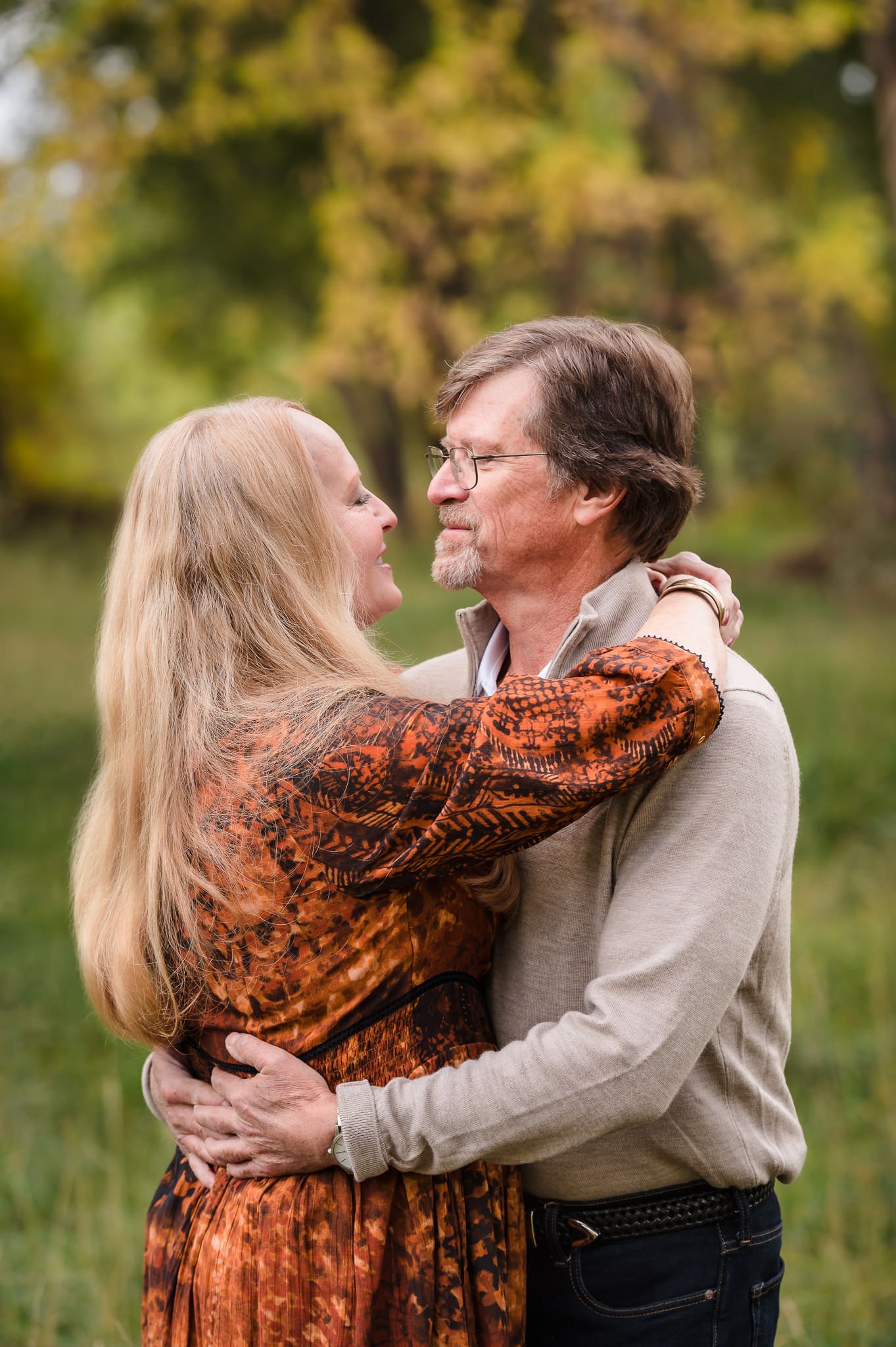 A woman places her arms around the shoulders of her husband and looks into his eyes during their 40th anniversary portrait session.