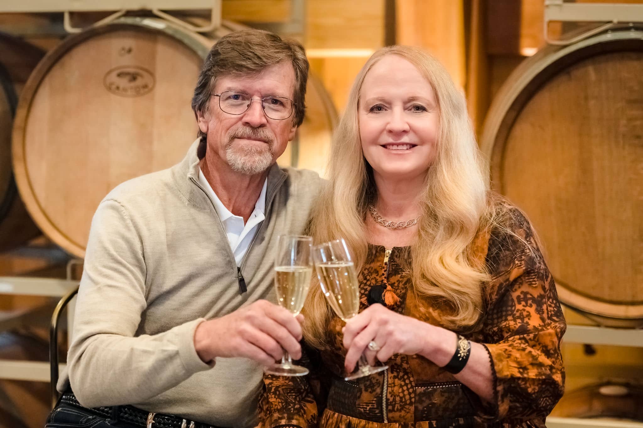 A man and woman share a toast in the barrel room at Sweet Heart Winery.