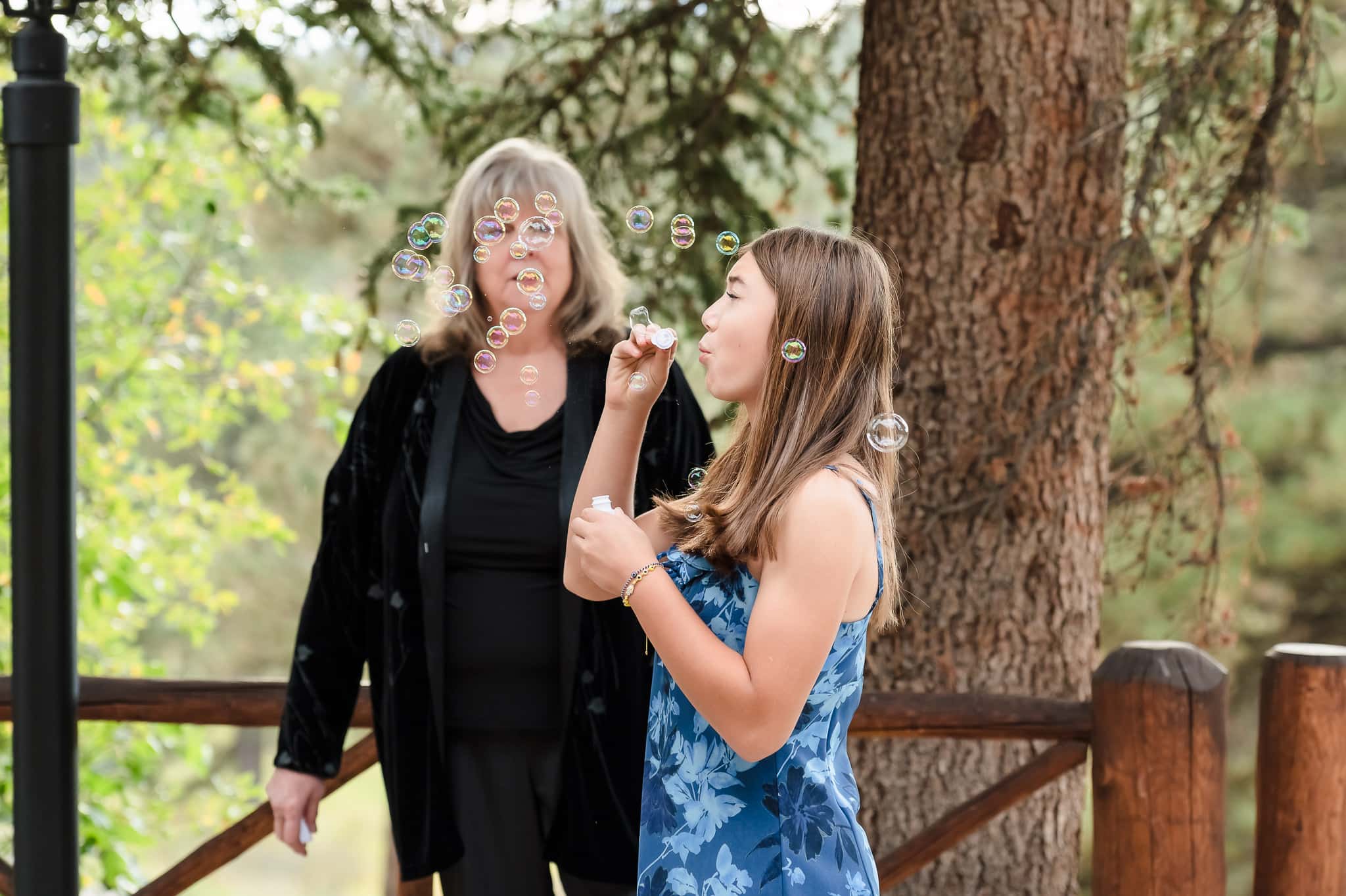 A young girl blows bubbles in anticipation of the vow renewal exit as a relative watches nearby.