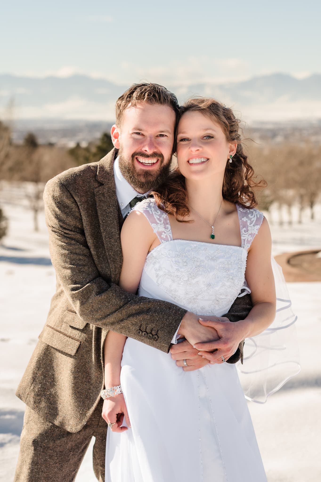Winter wedding photo of the wedding couple with the Rocky Mountains in the background.