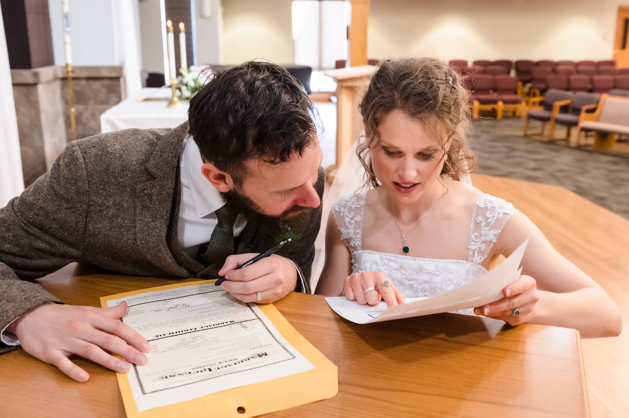 The bride and groom sort out the details on their marriage license before signing it.