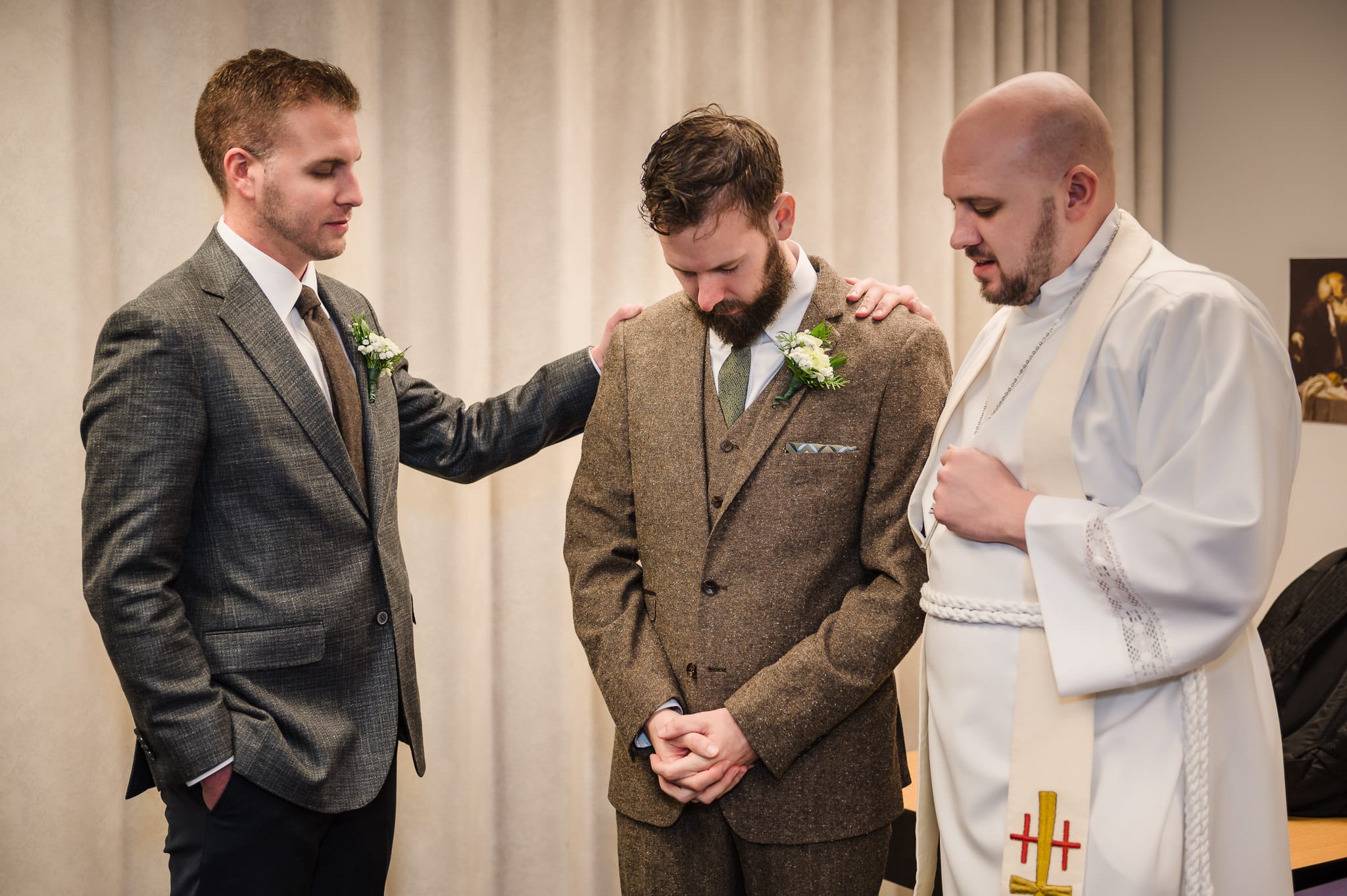 A prayerful moment before the ceremony with the best man, groom, and the officiant.