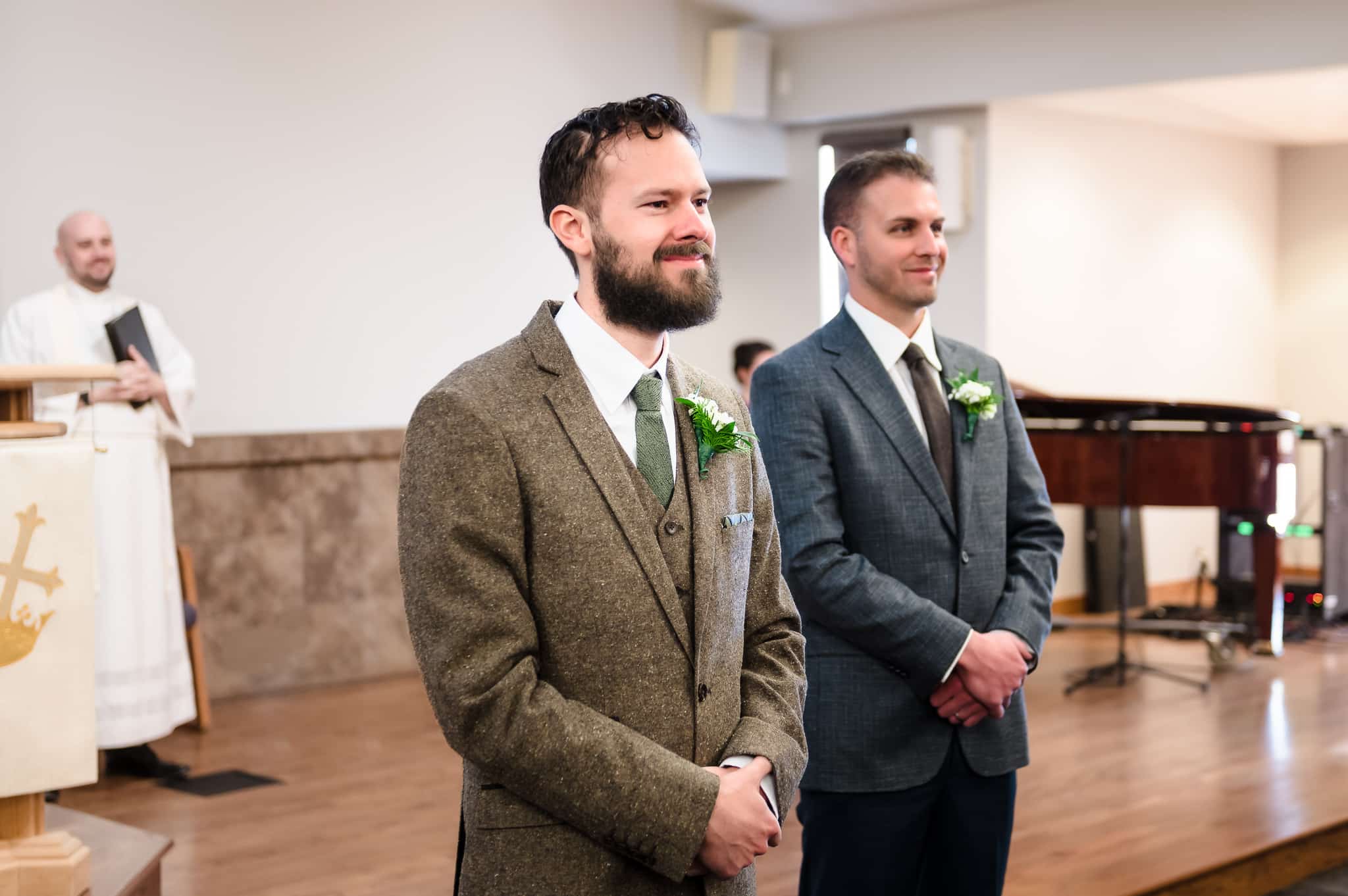 The groom smiles and beams as he sees his bride for the first time.