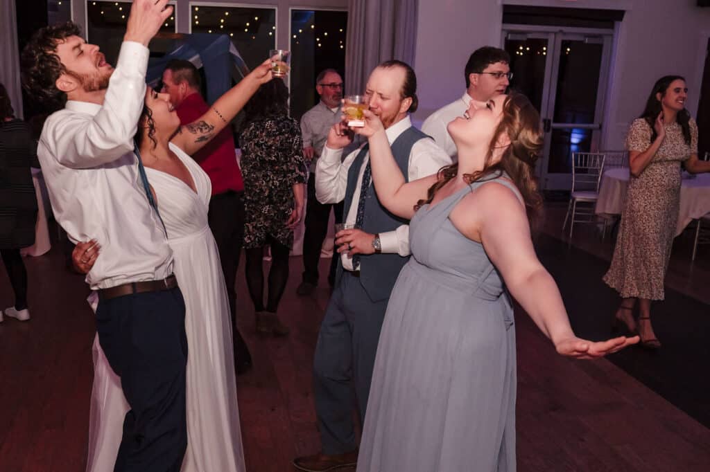 Guests fill the floor and dance at a wedding.