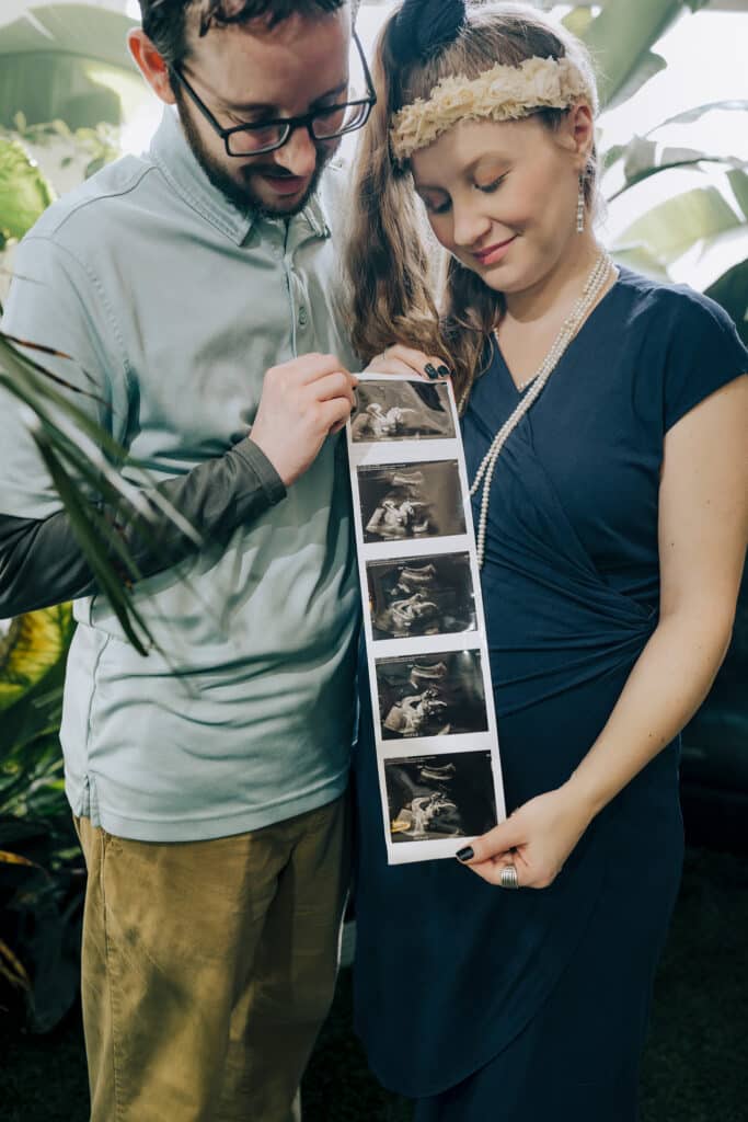 A man and expectant wife hold a sonagram of their unborn child.
