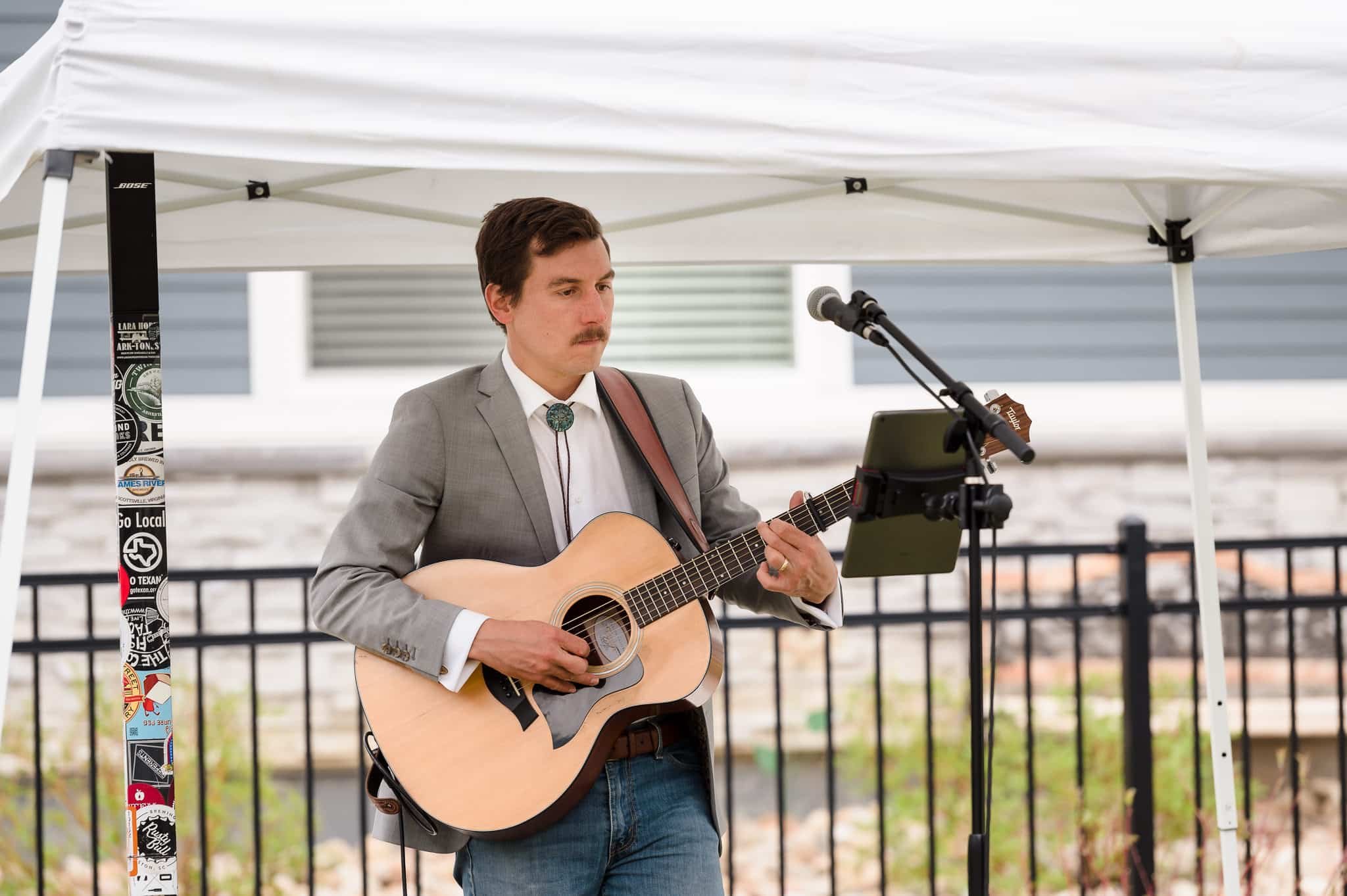 An acoustic guitar player entertains guests at a goodbye party.