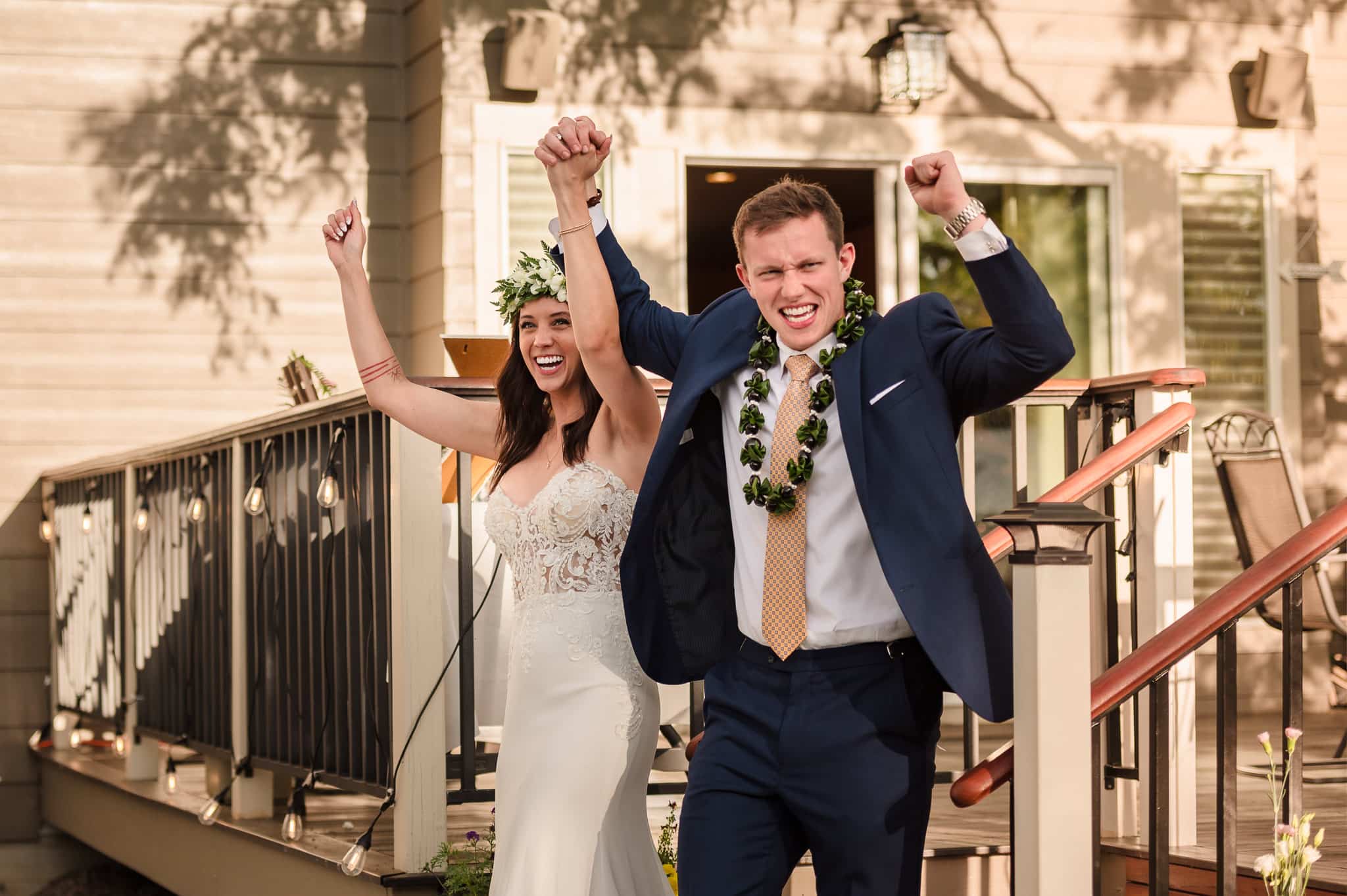The bride and groom raise their arms together in victory as they make their grand entrance to the reception.