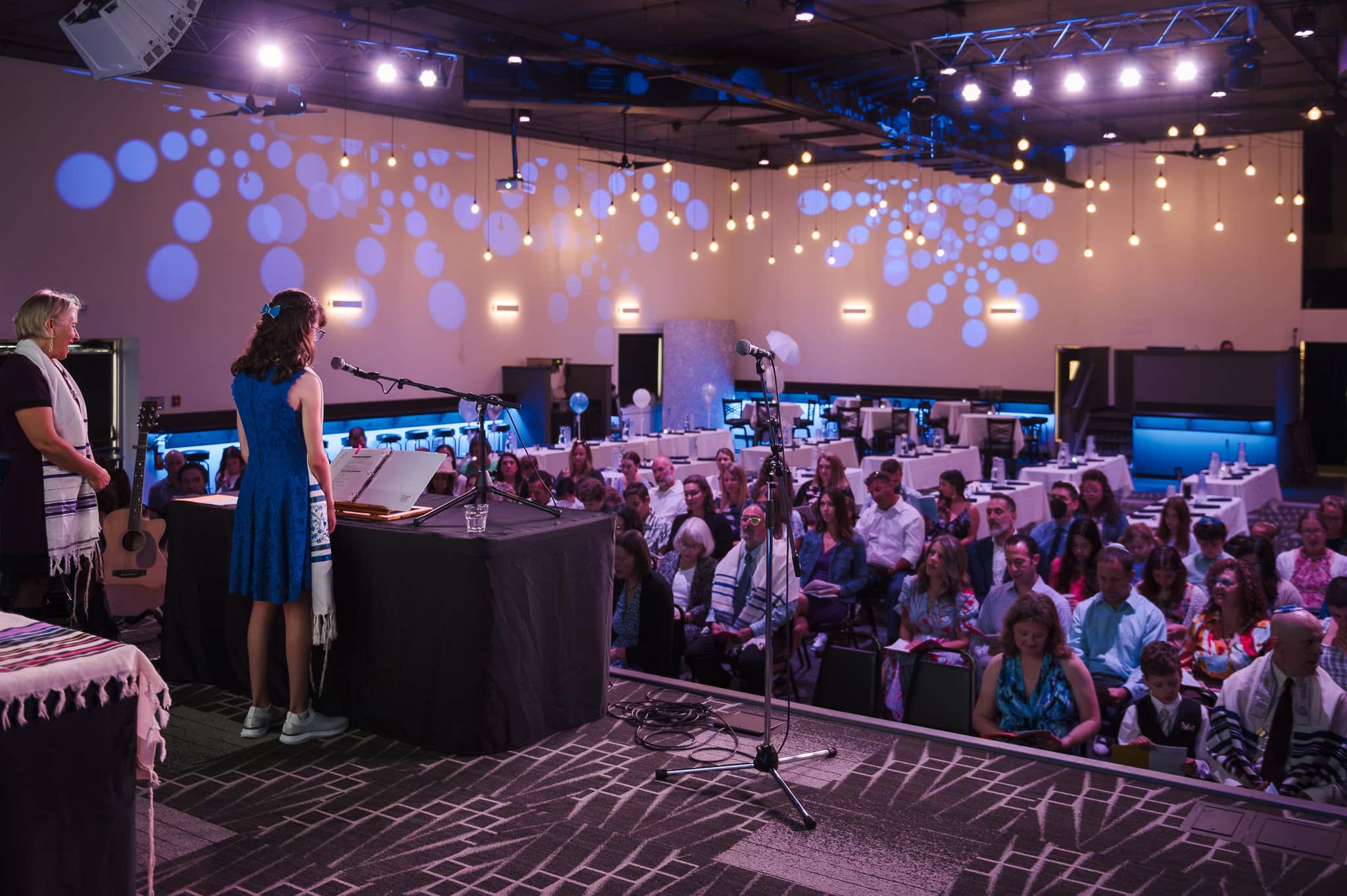 A side view of the stage looking out into the audience during a mitzvah celebration at Nissis event center in Lafayette, Colorado.