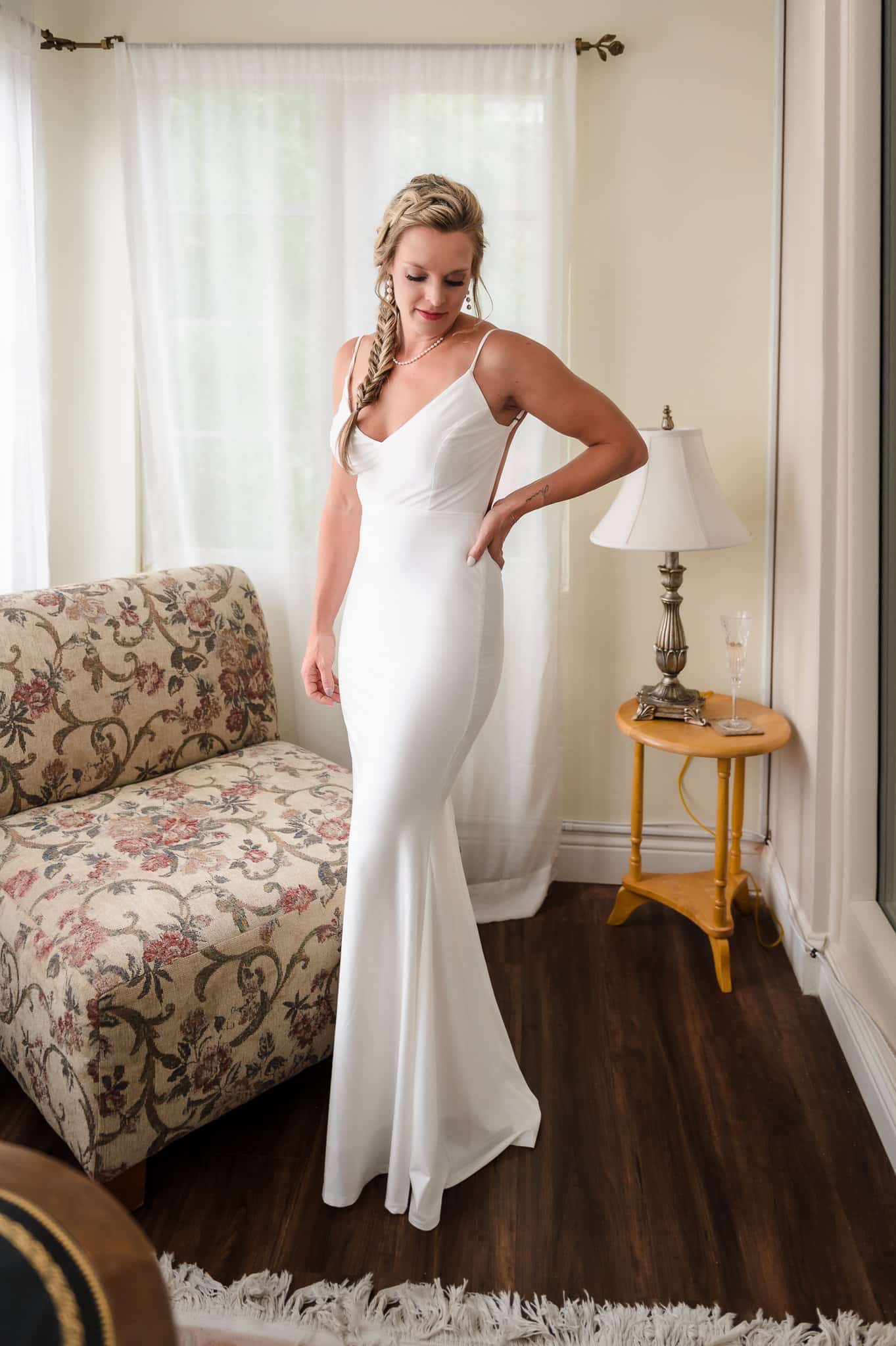 A bride shows of her beautiful figure in a white wedding dress as she readies for her 10-year vow renewal.