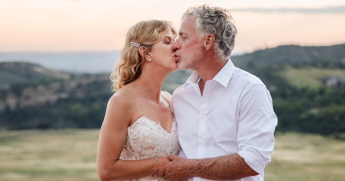 The bride and groom at sunset share a kiss.