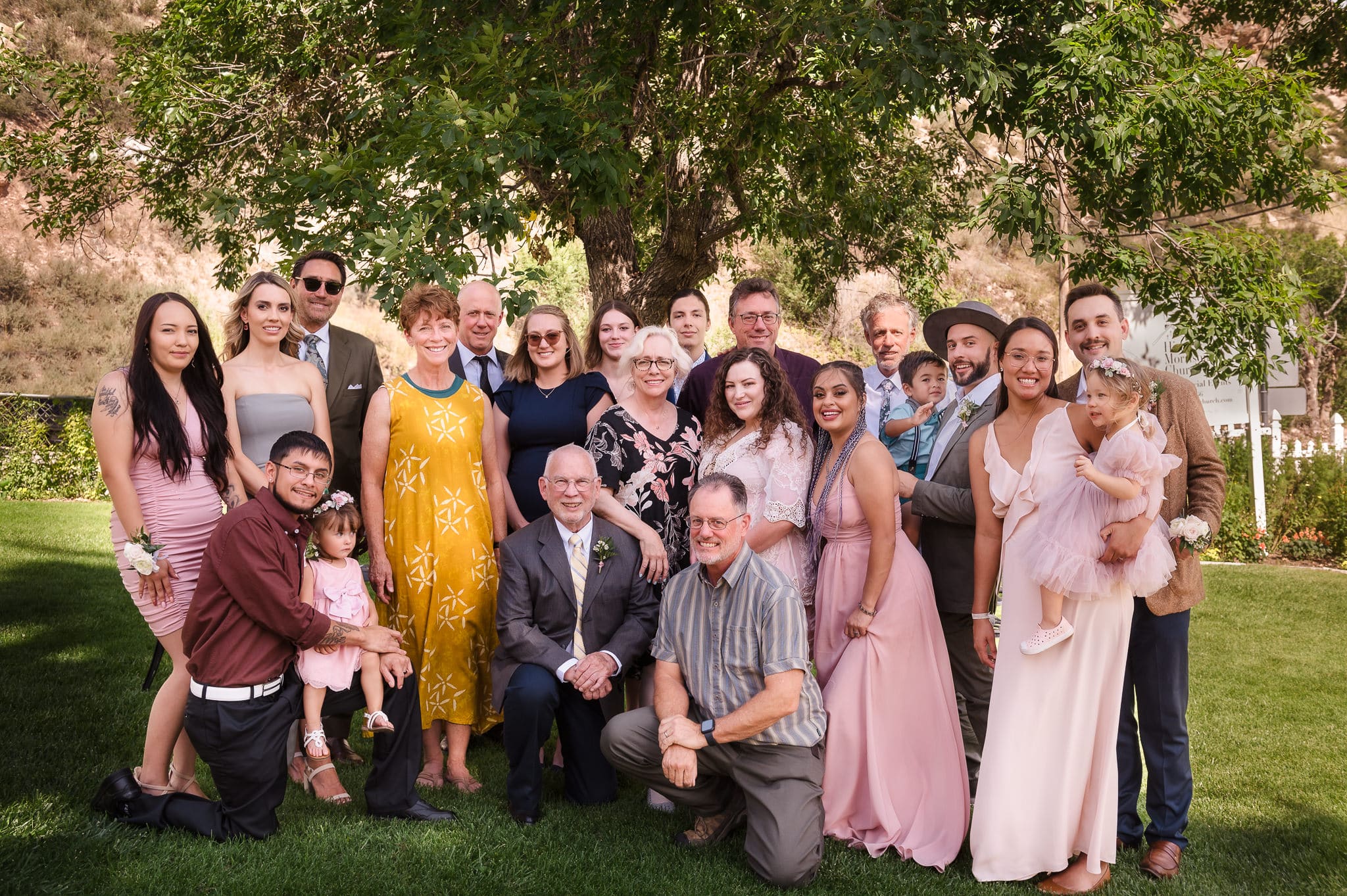 An extended family poses for a traditional portrait at a wedding.