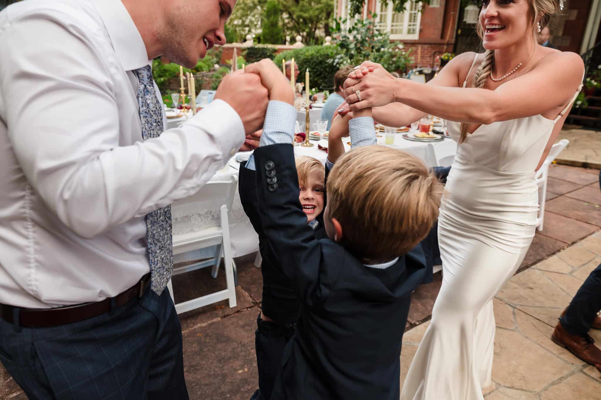 A mother and father with their two boys dance in a circle as a family at their vow renewal celebration.