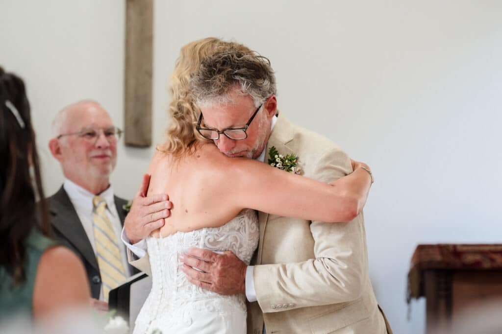 A groom hugs his bride at their wedding.