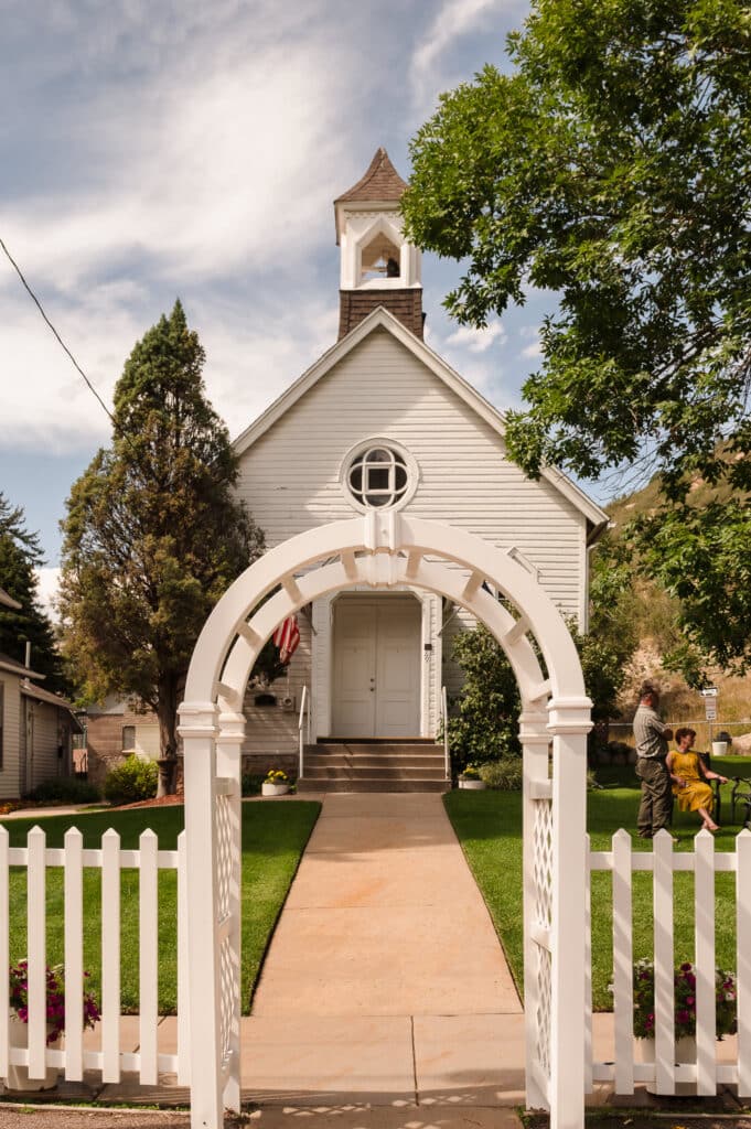 Historic charm abounds at the Historic Morrison Church shown here through the white picket fence and arbor.