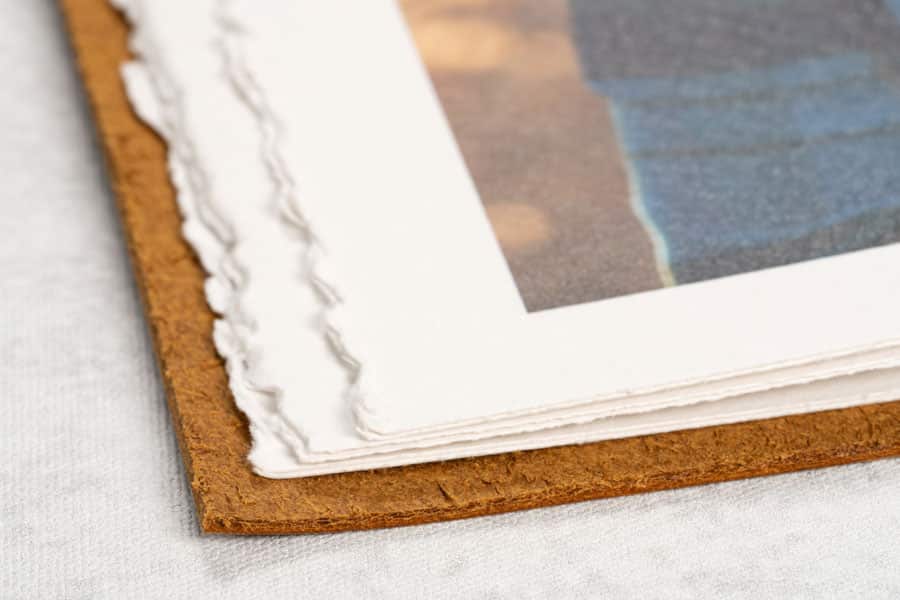 Close up of ripped style paper edges used in a rustic leather wrap album.