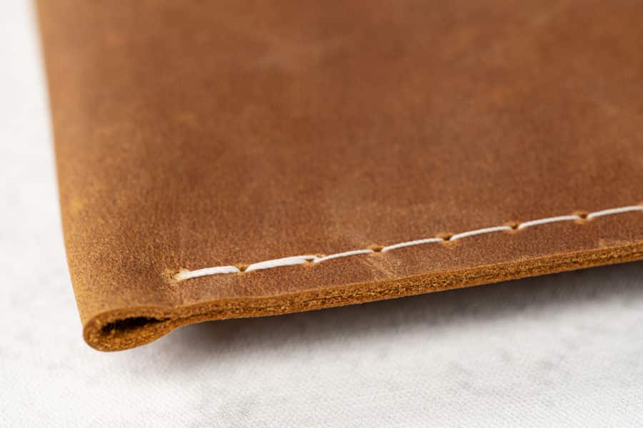 Close up of stitching used in a rustic leather-wrap style album.