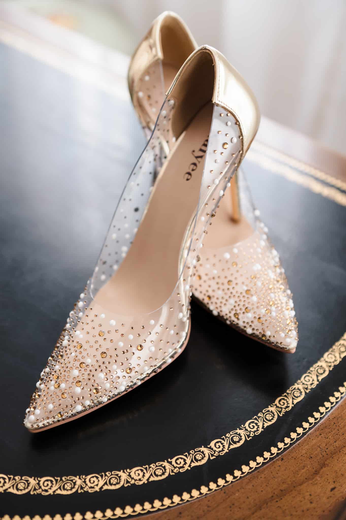 A pair of pearl and gold-sequined studded translucent shoes in a pump style.