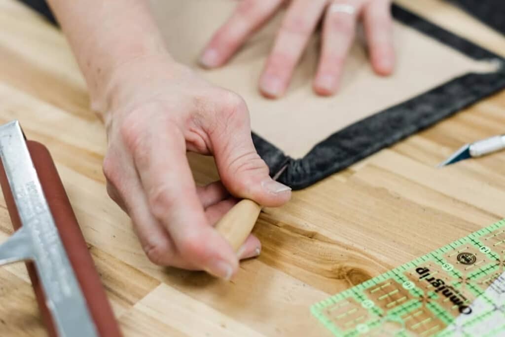 Close up of someone's hands as they craft an album and make the corners.