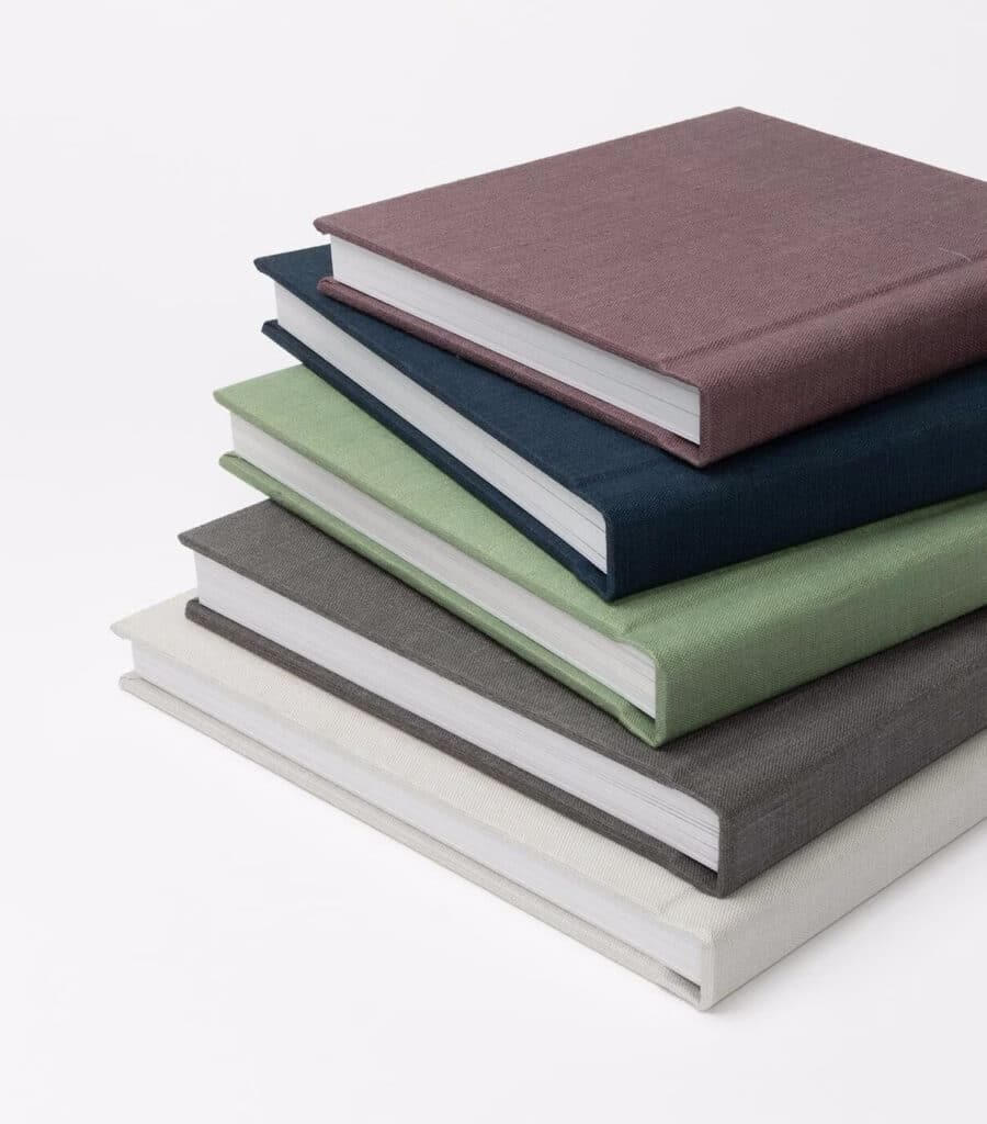 A stack of multiple linen albums in various colors.