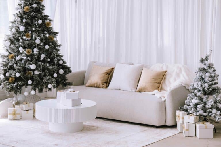 A glamorous but comfortable and homey studio decorated in white and gold with a tree.