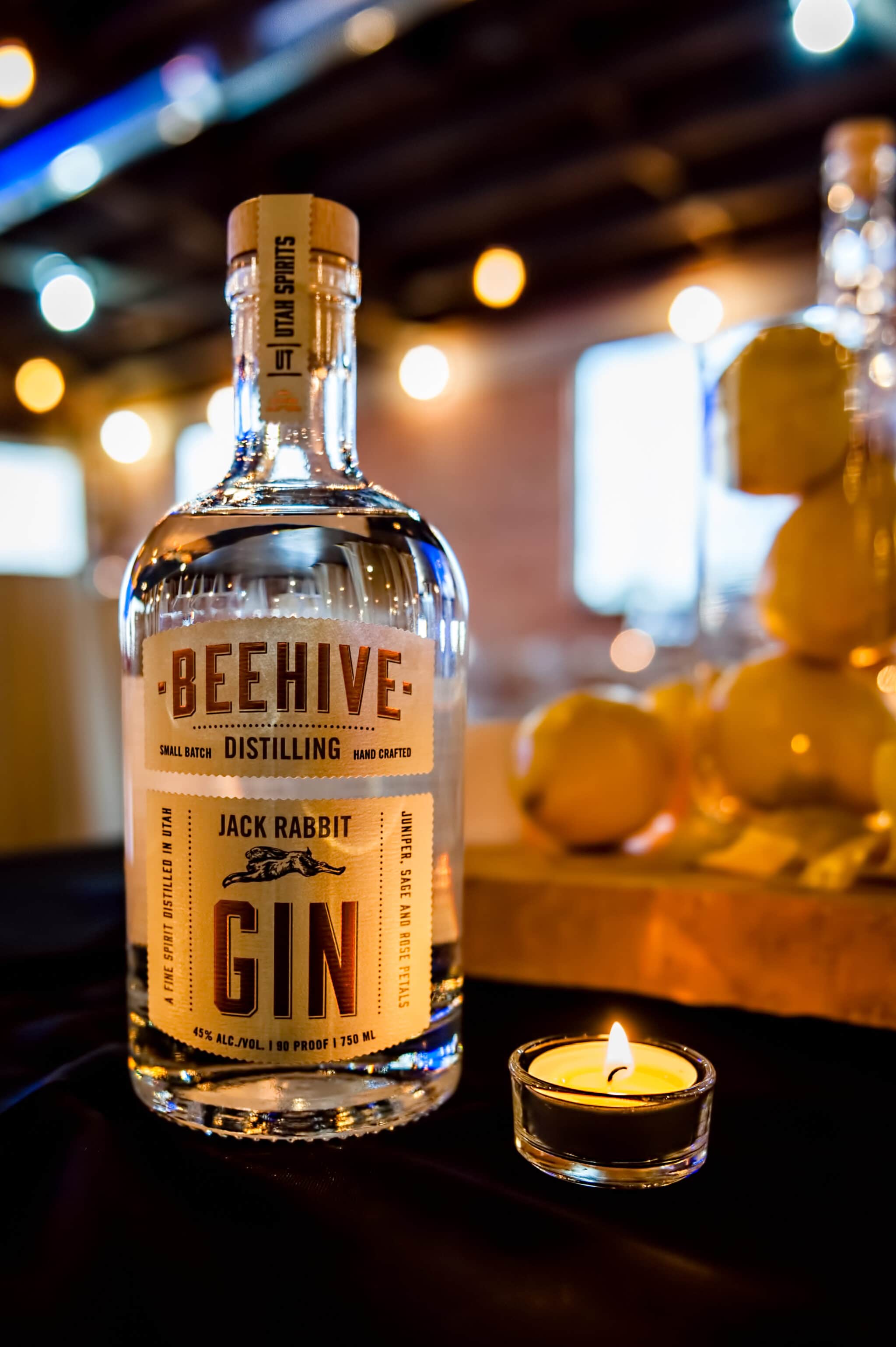 A large bottle of Beehive Gin in the soft candlelight at a fundraiser for a local public radio station.