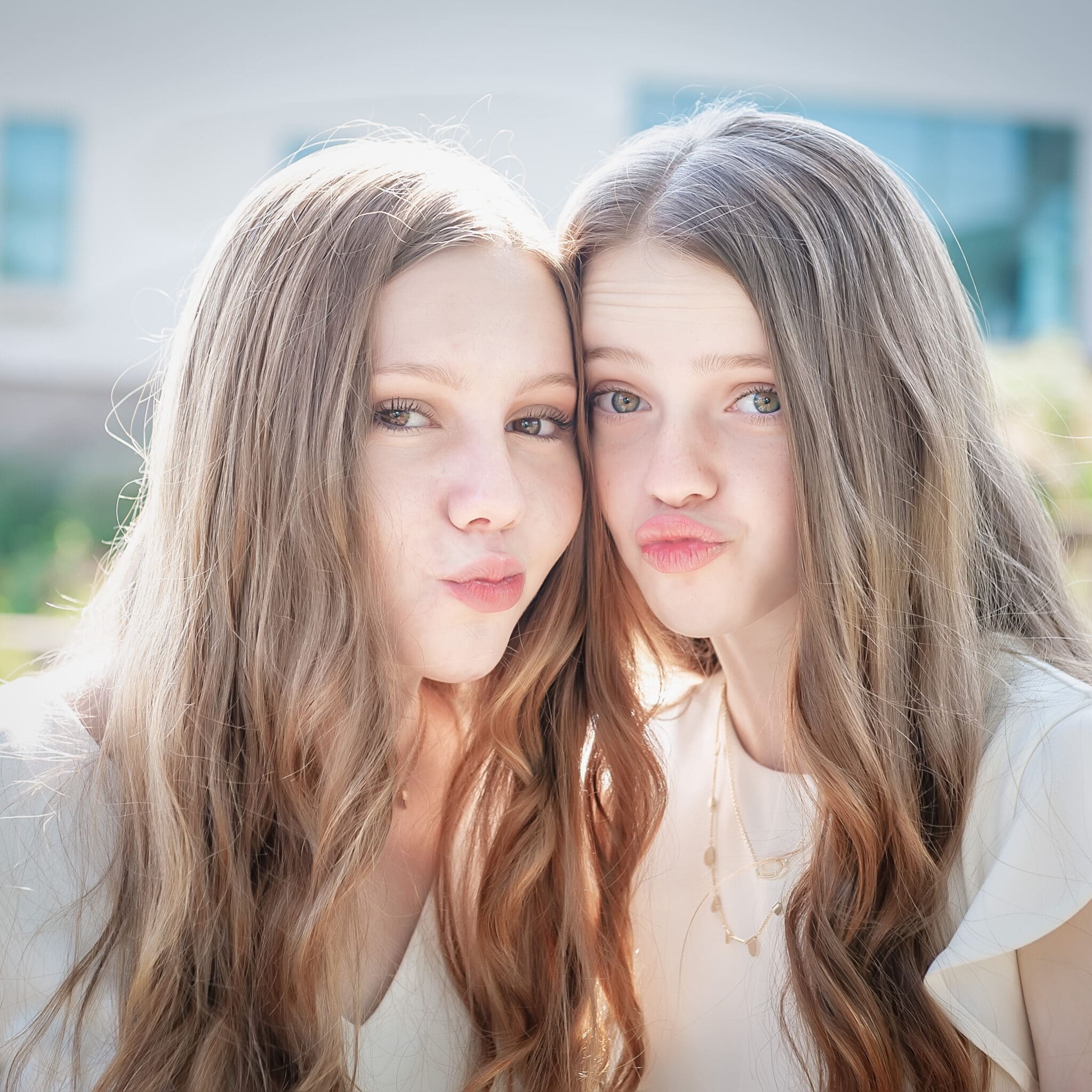 Two sisters make fishy lip faces.