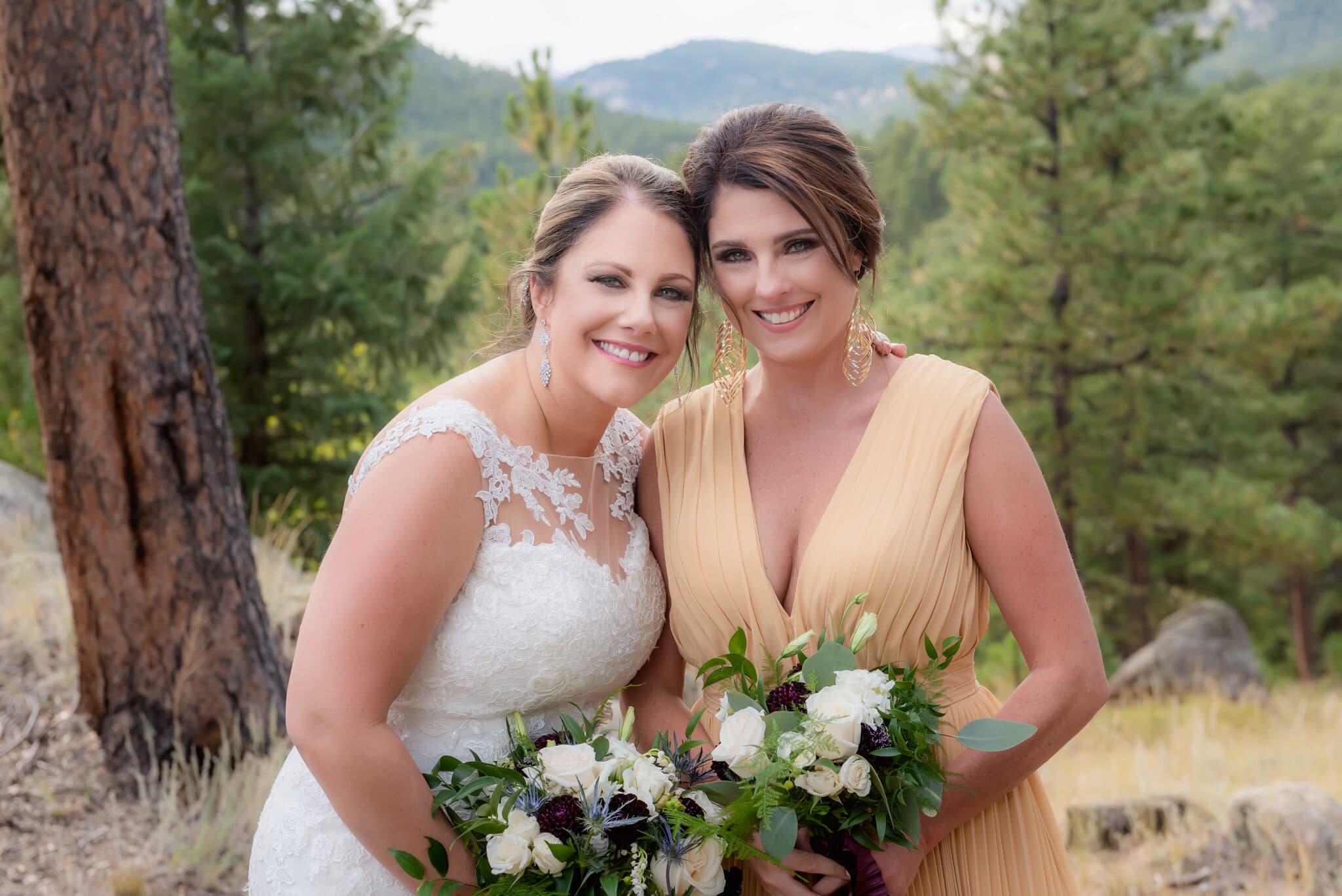 Bride and matron of honor in Evergreen, Colorado with fur trees and mountain view.