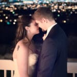 Evening portrait of newlyweds with city lights.