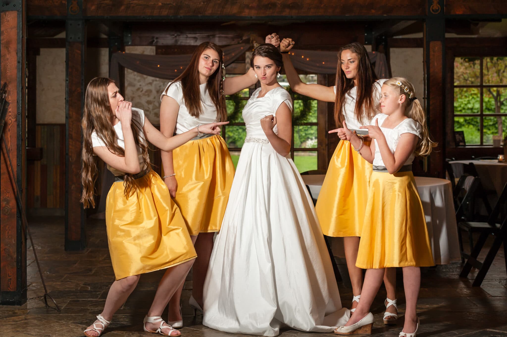 Strong bride and bridesmaids flex their muscles and act tough during their photo session.